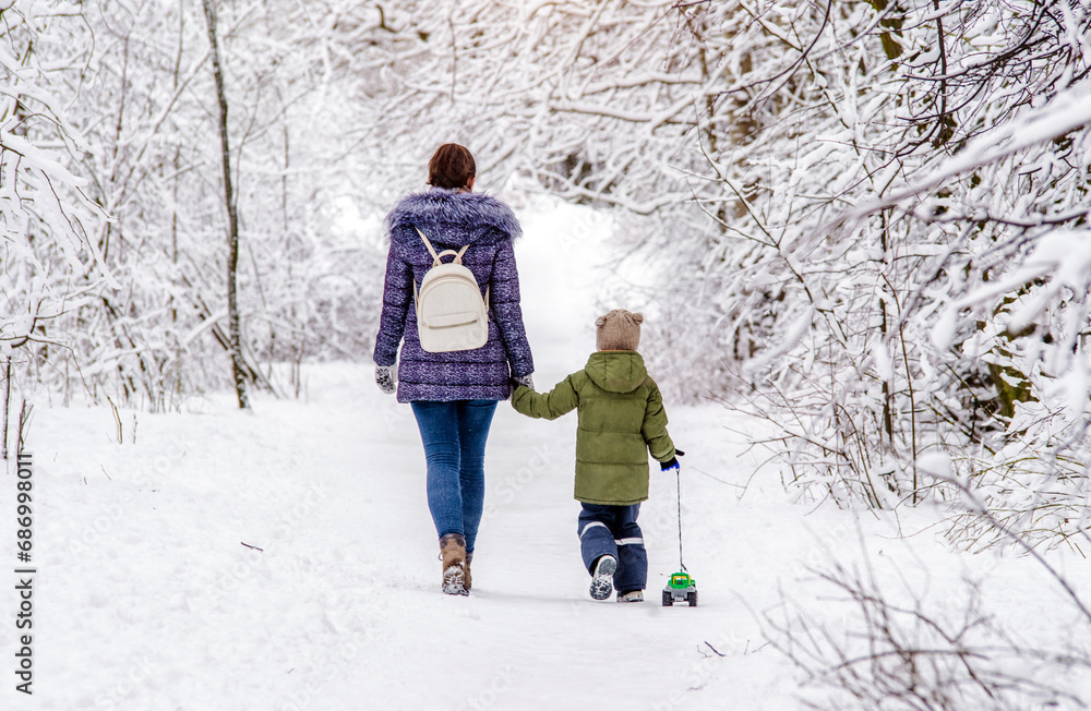 A woman with her son walking in a winter Park
