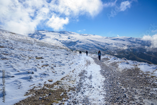 latin family walking through the snow in the mountains photo