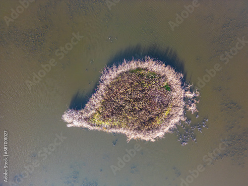 Aerial view of beautiful smooth green waters of a lake on a sunn