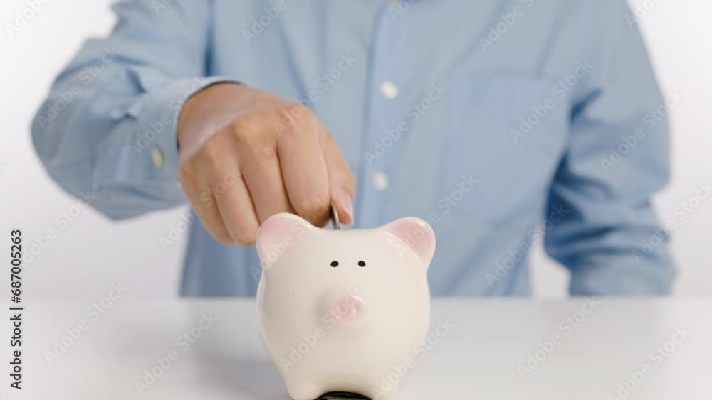 Businessman hand putting money in piggy bank for saving money and plan finance