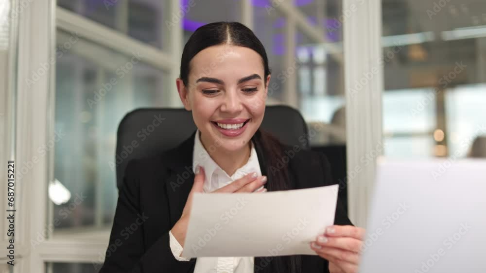 Happy woman entrepreneur with braided hair sitting and holding letter in hand and rejoicing about great news in office. Caucasian cheerful female enjoying success and victory on career ladder. Happy woman entrepreneur with braided hair sitting and holding letter in hand and rejoicing about great news in office. Caucasian cheerful female enjoying success and victory on career ladder.