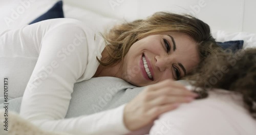 Relax, comfort and mom with child in bed for morning love, sleep and bonding together in home. Smile, embrace and wake up, happy mother and daughter in bedroom with support for woman and girl kid. photo