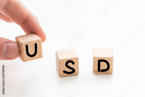 wooden blocks with the inscription usd and a block symbolizing the rise and fall of financial markets