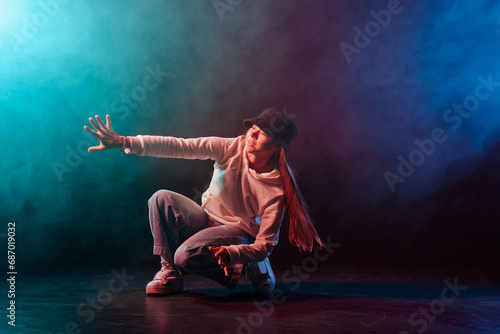 Fototapeta Naklejka Na Ścianę i Meble -  a girl in light clothes dances on a neon background in smoke, modern dance