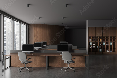 Modern office workplace interior with pc monitors on table, panoramic window