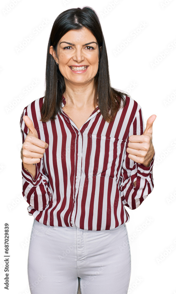 Beautiful brunette woman wearing striped shirt success sign doing positive gesture with hand, thumbs up smiling and happy. cheerful expression and winner gesture. Beautiful brunette woman wearing striped shirt success sign doing positive gesture with hand, thumbs up smiling and happy. cheerful expression and winner gesture.