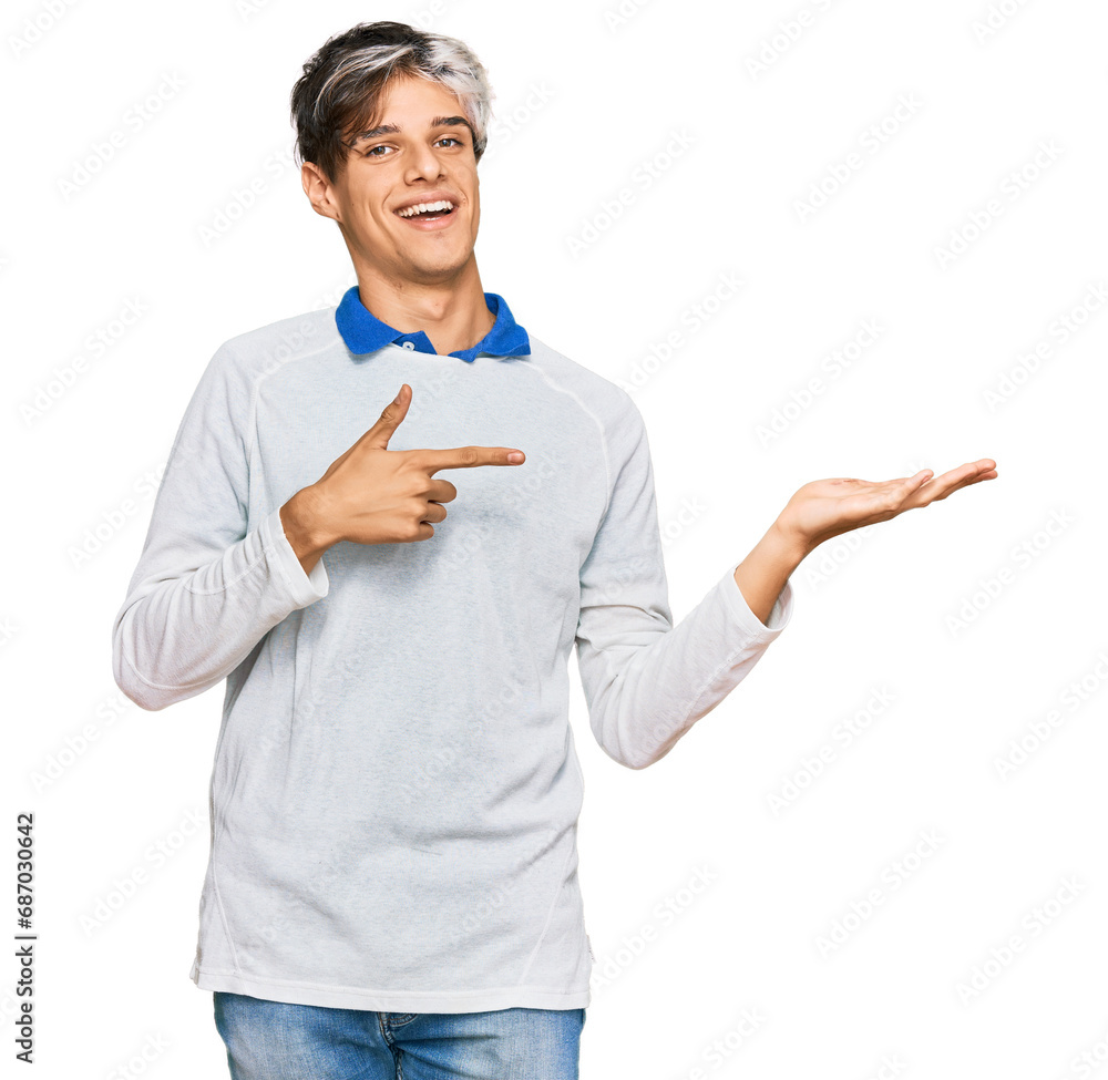 Young hispanic man wearing casual clothes amazed and smiling to the camera while presenting with hand and pointing with finger. Young hispanic man wearing casual clothes amazed and smiling to the camera while presenting with hand and pointing with finger.