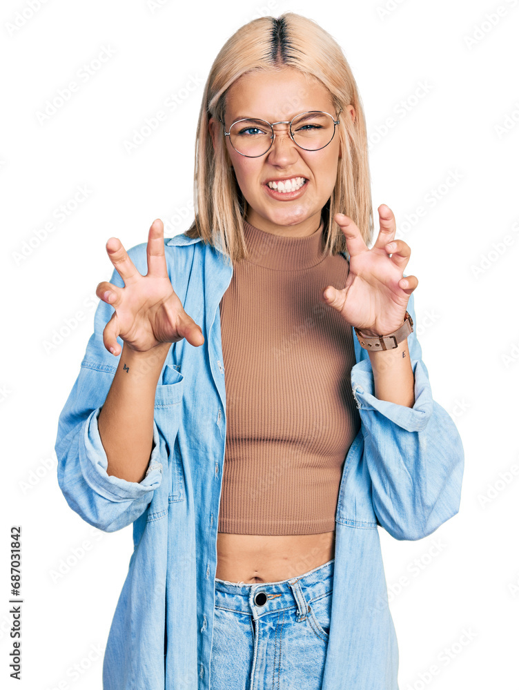 Obraz premium Beautiful young blonde woman wearing glasses smiling funny doing claw gesture as cat, aggressive and sexy expression