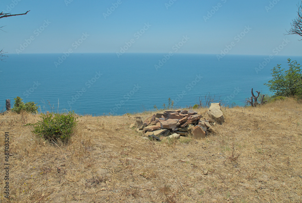 Landscape from a hill cliff with trees and bushes to the blue sea and clear horizon Landscape from a hill cliff with trees and bushes to the blue sea and clear horizon