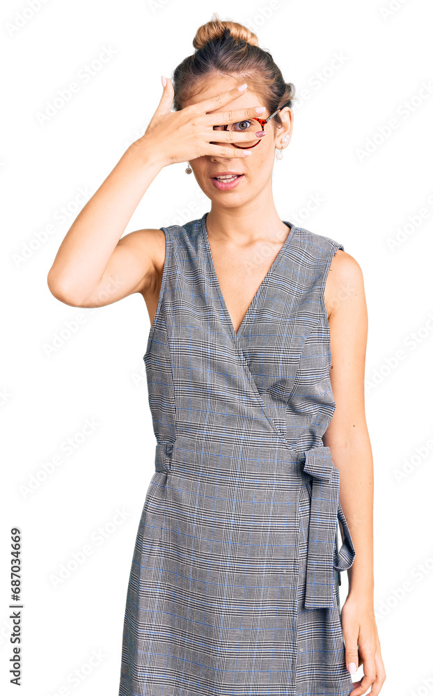 Beautiful caucasian woman with blonde hair wearing business clothes and glasses peeking in shock covering face and eyes with hand, looking through fingers with embarrassed expression. Beautiful caucasian woman with blonde hair wearing business clothes and glasses peeking in shock covering face and eyes with hand, looking through fingers with embarrassed expression.