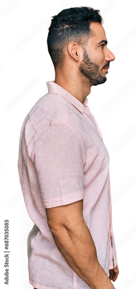 Hispanic man with beard wearing casual shirt looking to side, relax profile pose with natural face with confident smile. Hispanic man with beard wearing casual shirt looking to side, relax profile pose with natural face with confident smile.