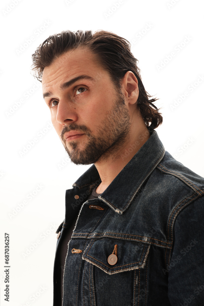 Obraz premium Handsome bearded young man wearing denim jacket posing on the white background.