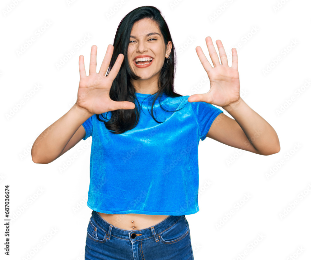 Young hispanic woman wearing casual clothes showing and pointing up with fingers number ten while smiling confident and happy. Young hispanic woman wearing casual clothes showing and pointing up with fingers number ten while smiling confident and happy.