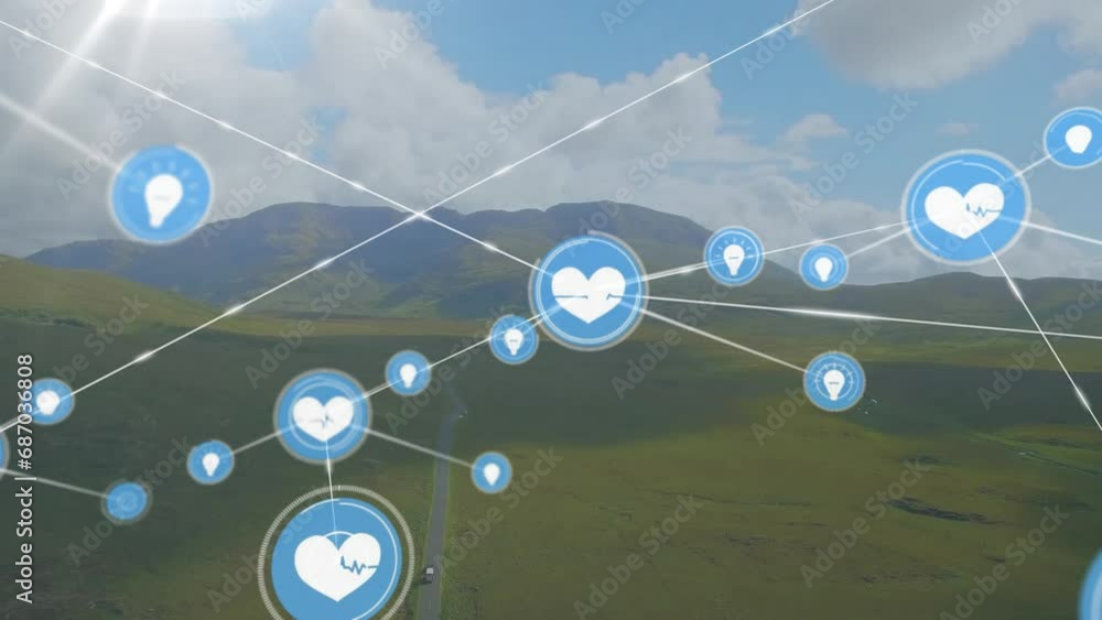 Animation of connected icons over aerial view of green landscape against mountains and cloudy sky Animation of connected icons over aerial view of green landscape against mountains and cloudy sky