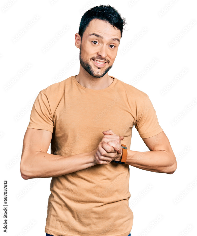 Obraz premium Hispanic man with beard wearing casual t shirt with hands together and crossed fingers smiling relaxed and cheerful. success and optimistic