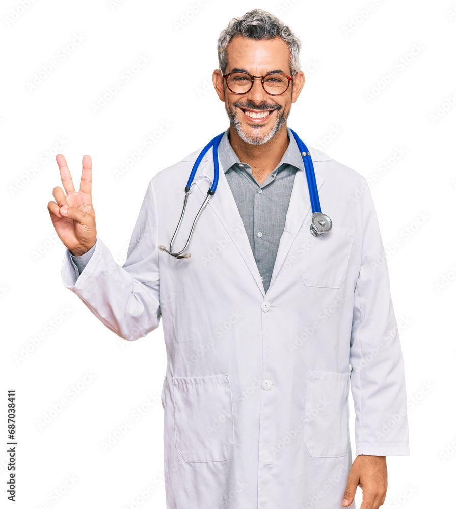 Middle age grey-haired man wearing doctor uniform and stethoscope smiling with happy face winking at the camera doing victory sign. number two. Middle age grey-haired man wearing doctor uniform and stethoscope smiling with happy face winking at the camera doing victory sign. number two.