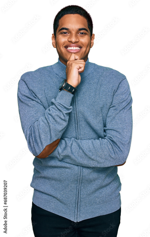Young handsome hispanic man wearing casual sweatshirt looking confident at the camera smiling with crossed arms and hand raised on chin. thinking positive. Young handsome hispanic man wearing casual sweatshirt looking confident at the camera smiling with crossed arms and hand raised on chin. thinking positive.