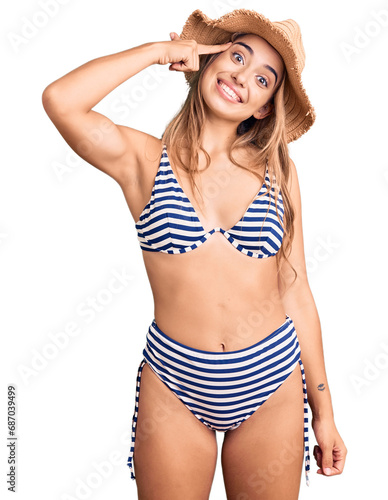 Young beautiful blonde woman wearing bikini and hat smiling pointing to head with one finger, great idea or thought, good memory © Krakenimages.com