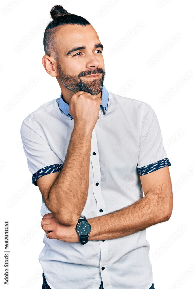 Hispanic man with ponytail wearing casual white shirt with hand on chin thinking about question, pensive expression. smiling and thoughtful face. doubt concept. Hispanic man with ponytail wearing casual white shirt with hand on chin thinking about question, pensive expression. smiling and thoughtful face. doubt concept.