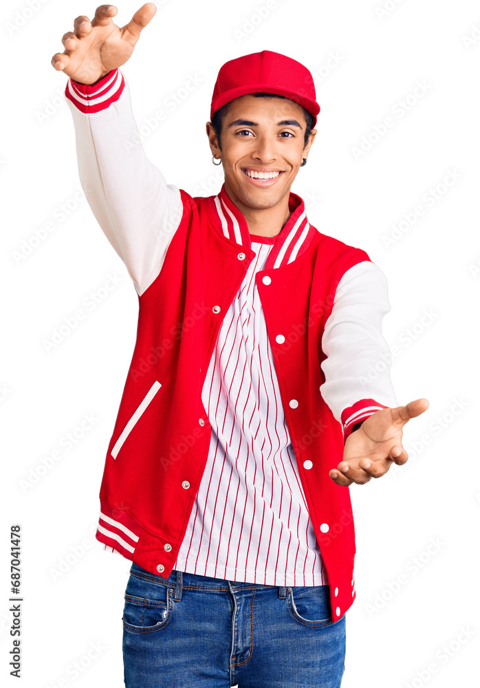 Young african amercian man wearing baseball uniform looking at the camera smiling with open arms for hug. cheerful expression embracing happiness. Young african amercian man wearing baseball uniform looking at the camera smiling with open arms for hug. cheerful expression embracing happiness.