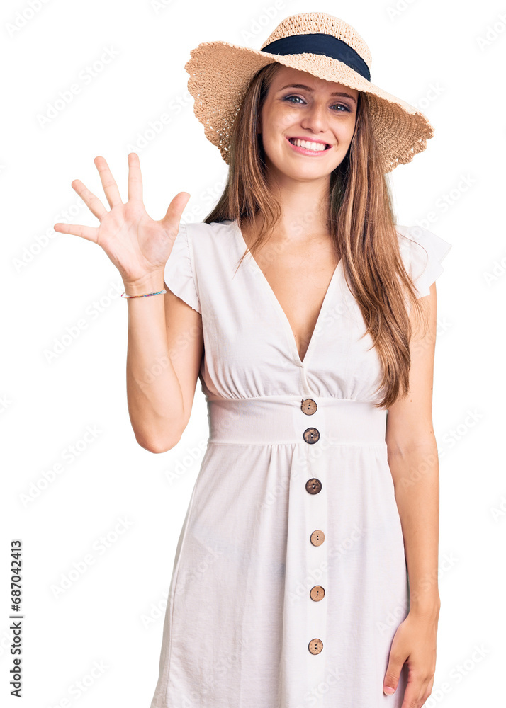 Young beautiful blonde woman wearing summer dress and hat showing and pointing up with fingers number five while smiling confident and happy. Young beautiful blonde woman wearing summer dress and hat showing and pointing up with fingers number five while smiling confident and happy.