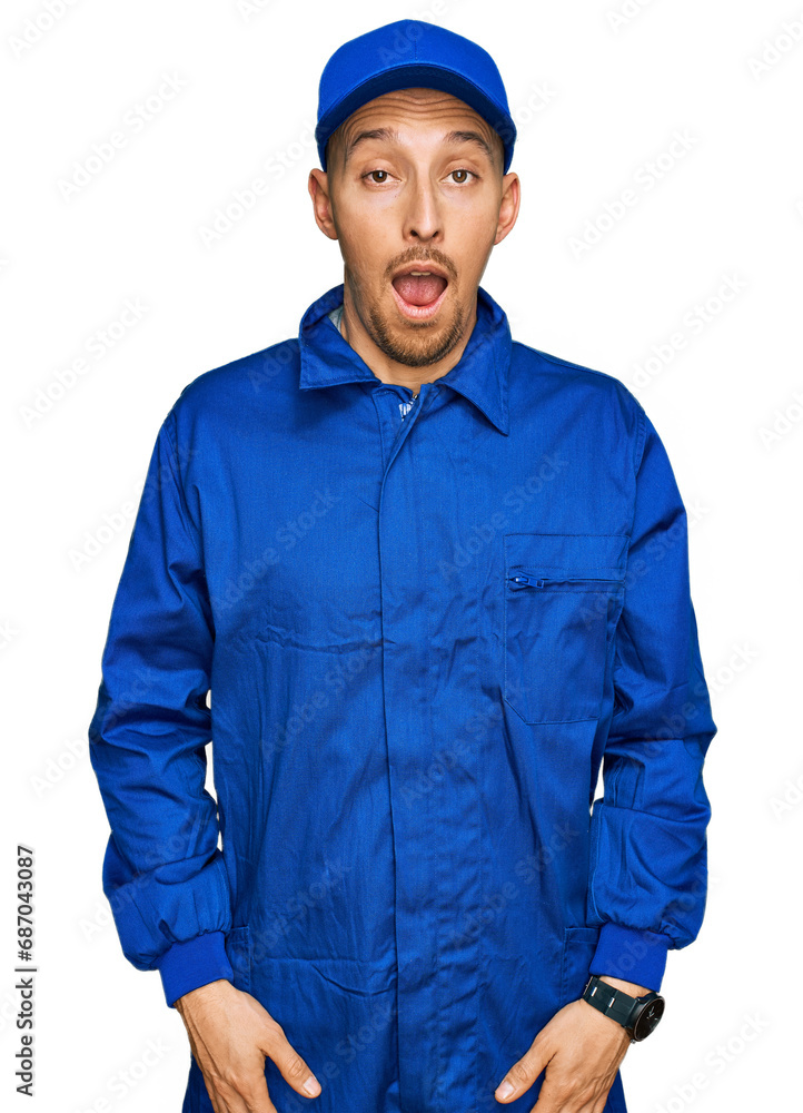 Bald man with beard wearing builder jumpsuit uniform afraid and shocked with surprise and amazed expression, fear and excited face. Bald man with beard wearing builder jumpsuit uniform afraid and shocked with surprise and amazed expression, fear and excited face.