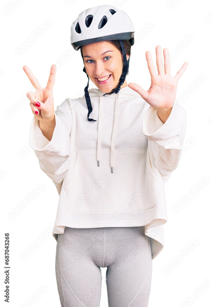 Beautiful brunette young woman wearing bike helmet and sporty clothes showing and pointing up with fingers number seven while smiling confident and happy. Beautiful brunette young woman wearing bike helmet and sporty clothes showing and pointing up with fingers number seven while smiling confident and happy.