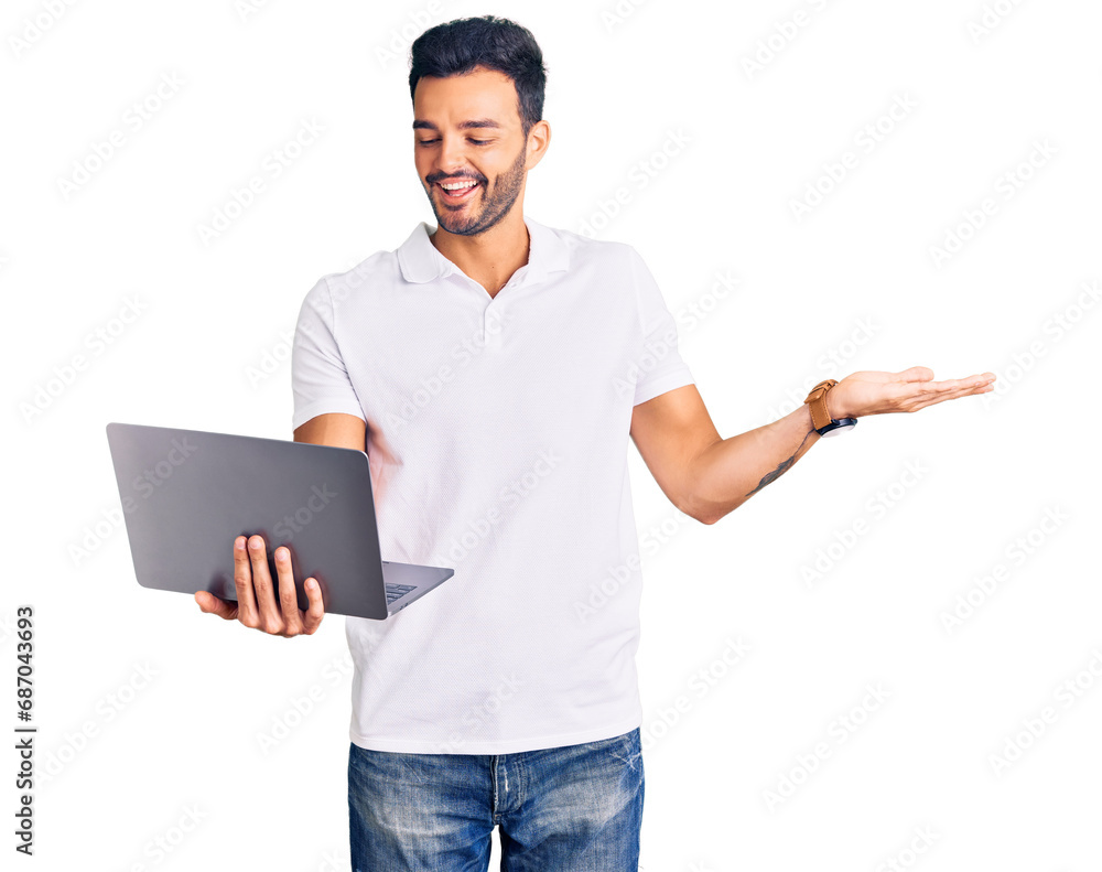 Young handsome hispanic man working using computer laptop celebrating victory with happy smile and winner expression with raised hands