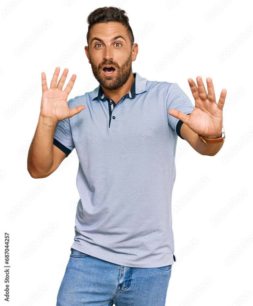 Handsome man with beard wearing casual clothes afraid and terrified with fear expression stop gesture with hands, shouting in shock. panic concept. Handsome man with beard wearing casual clothes afraid and terrified with fear expression stop gesture with hands, shouting in shock. panic concept.