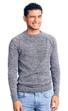 Hispanic handsome young man wearing casual sweater winking looking at the camera with sexy expression, cheerful and happy face.