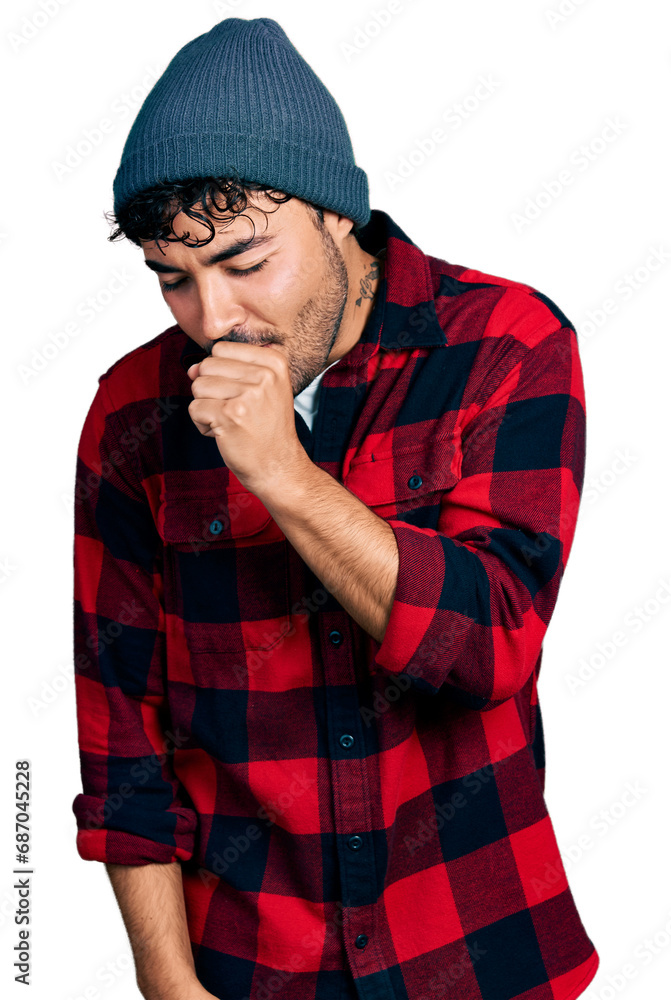 Hispanic young man with beard wearing wool winter hat feeling unwell and coughing as symptom for cold or bronchitis. health care concept. Hispanic young man with beard wearing wool winter hat feeling unwell and coughing as symptom for cold or bronchitis. health care concept.