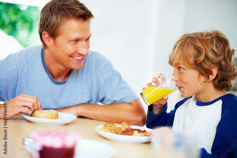Happy family, morning and breakfast on weekend, looking and eating for nutrition, orange juice and donut. Father, child and enjoying food together for hunger, health and energy for good day Happy family, morning and breakfast on weekend, looking and eating for nutrition, orange juice and donut. Father, child and enjoying food together for hunger, health and energy for good day