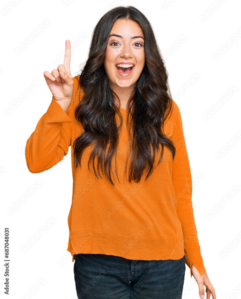 Beautiful brunette young woman wearing casual orange sweater pointing finger up with successful idea. exited and happy. number one. Beautiful brunette young woman wearing casual orange sweater pointing finger up with successful idea. exited and happy. number one.