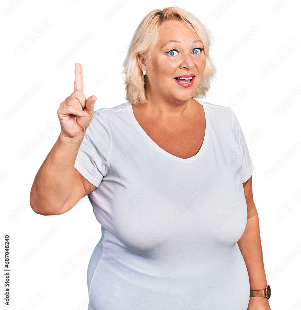 Middle age blonde woman wearing casual white t shirt pointing finger up with successful idea. exited and happy. number one. Middle age blonde woman wearing casual white t shirt pointing finger up with successful idea. exited and happy. number one.