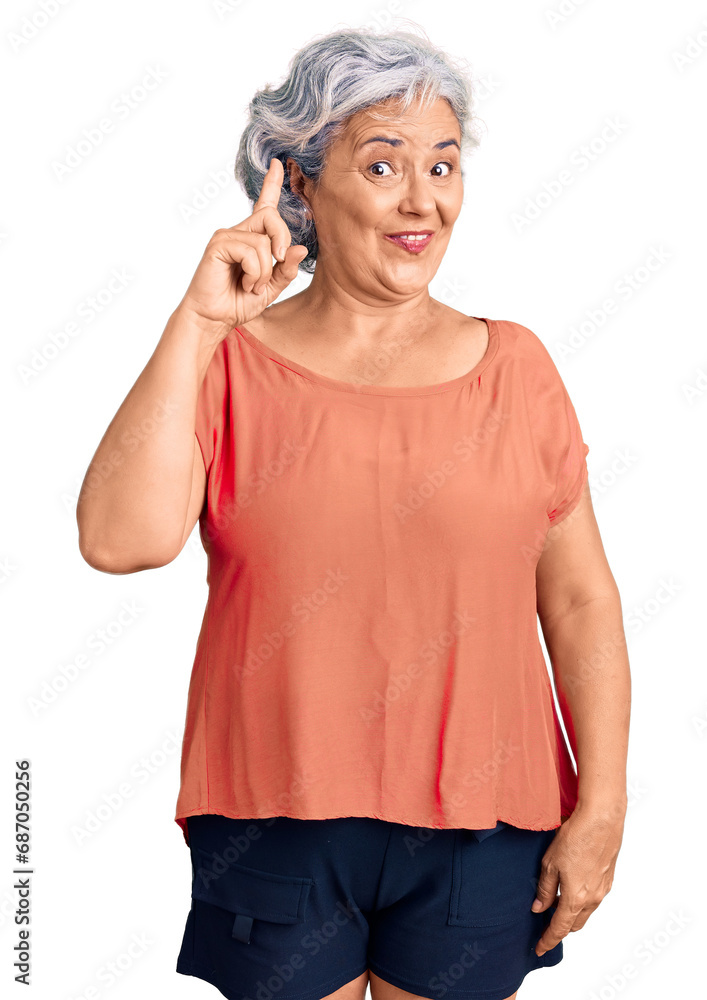 Senior woman with gray hair wearing orange tshirt pointing finger up with successful idea. exited and happy. number one. Senior woman with gray hair wearing orange tshirt pointing finger up with successful idea. exited and happy. number one.