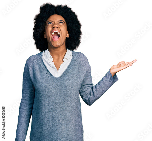 Young african american woman presenting with open palm angry and mad screaming frustrated and furious, shouting with anger looking up.