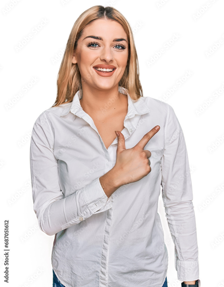 Young caucasian woman wearing casual clothes cheerful with a smile on face pointing with hand and finger up to the side with happy and natural expression Young caucasian woman wearing casual clothes cheerful with a smile on face pointing with hand and finger up to the side with happy and natural expression