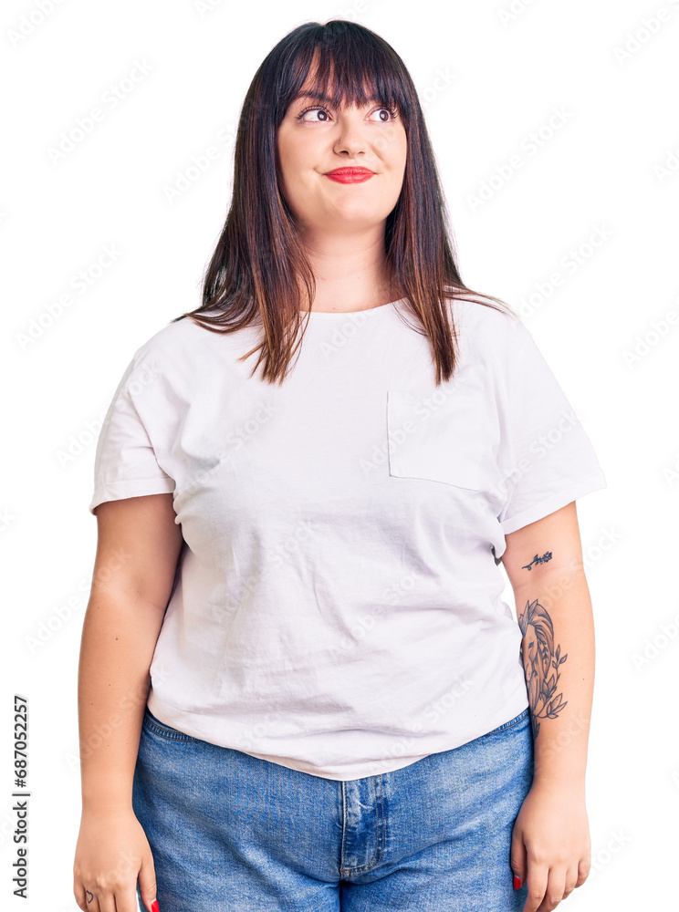 Young plus size woman wearing casual clothes smiling looking to the side and staring away thinking. Young plus size woman wearing casual clothes smiling looking to the side and staring away thinking.