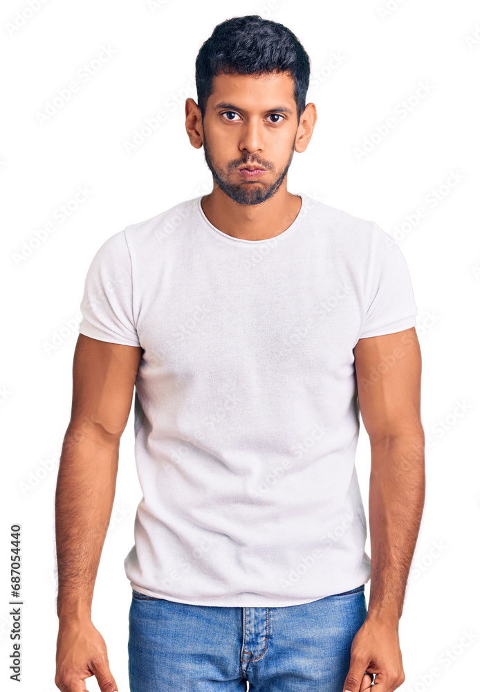 Young latin man wearing casual clothes puffing cheeks with funny face. mouth inflated with air, crazy expression. Young latin man wearing casual clothes puffing cheeks with funny face. mouth inflated with air, crazy expression.