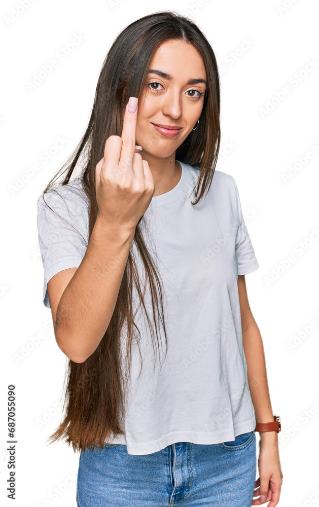 Young hispanic girl wearing casual white t shirt showing middle finger, impolite and rude fuck off expression Young hispanic girl wearing casual white t shirt showing middle finger, impolite and rude fuck off expression