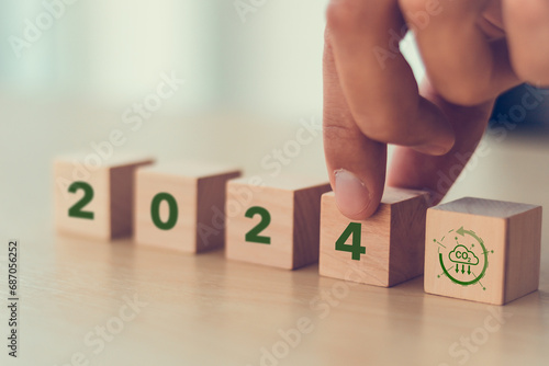 Reducing carbon emissions target in 2024. Green business, enviromental sustainability. Climate action, carbon offset and neutrality strategies. 2024 written on wooden cubes and decarbonization icons.