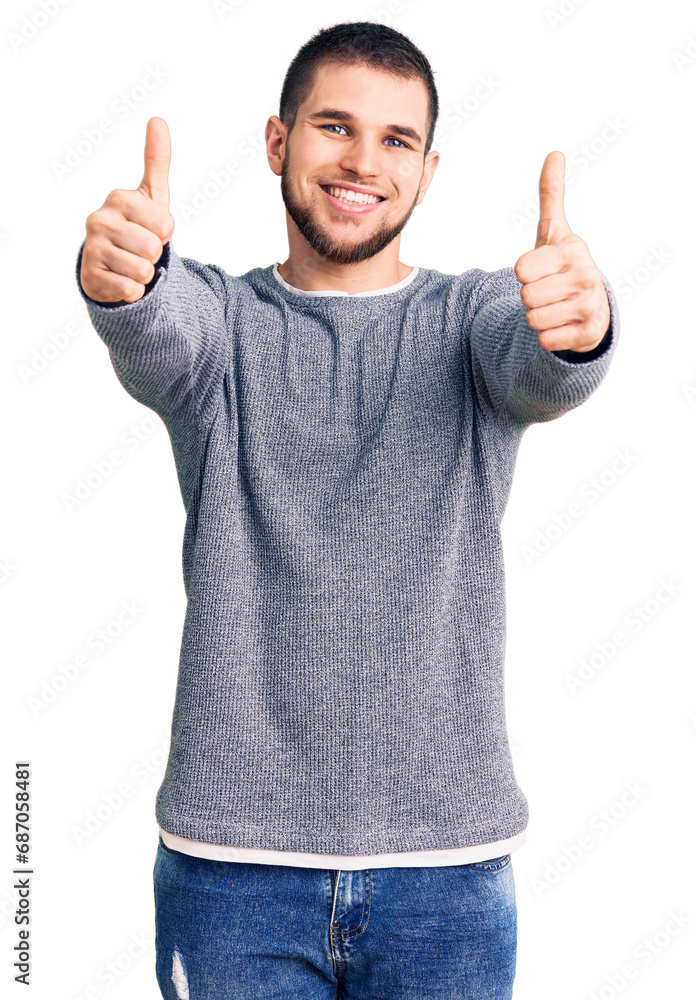 Young handsome man wearing casual sweater approving doing positive gesture with hand, thumbs up smiling and happy for success. winner gesture. Young handsome man wearing casual sweater approving doing positive gesture with hand, thumbs up smiling and happy for success. winner gesture.