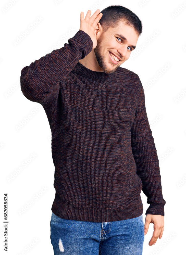 Young handsome man wearing casual sweater smiling with hand over ear listening an hearing to rumor or gossip. deafness concept. Young handsome man wearing casual sweater smiling with hand over ear listening an hearing to rumor or gossip. deafness concept.