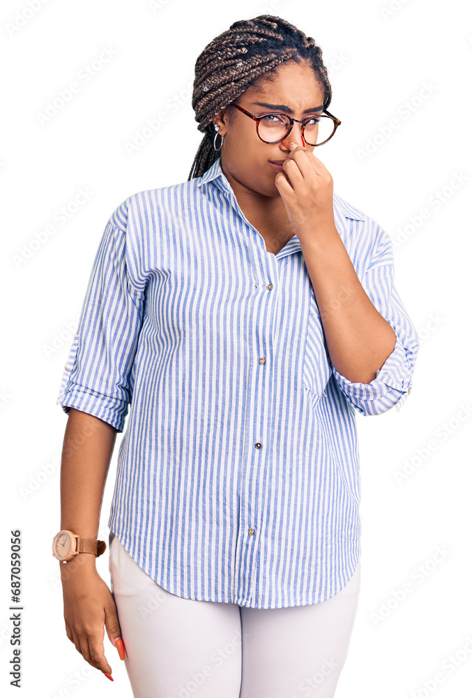 Young african american woman with braids wearing casual clothes and glasses smelling something stinky and disgusting, intolerable smell, holding breath with fingers on nose. bad smell Young african american woman with braids wearing casual clothes and glasses smelling something stinky and disgusting, intolerable smell, holding breath with fingers on nose. bad smell