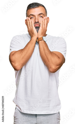 Middle age handsome man wearing casual white tshirt tired hands covering face, depression and sadness, upset and irritated for problem
