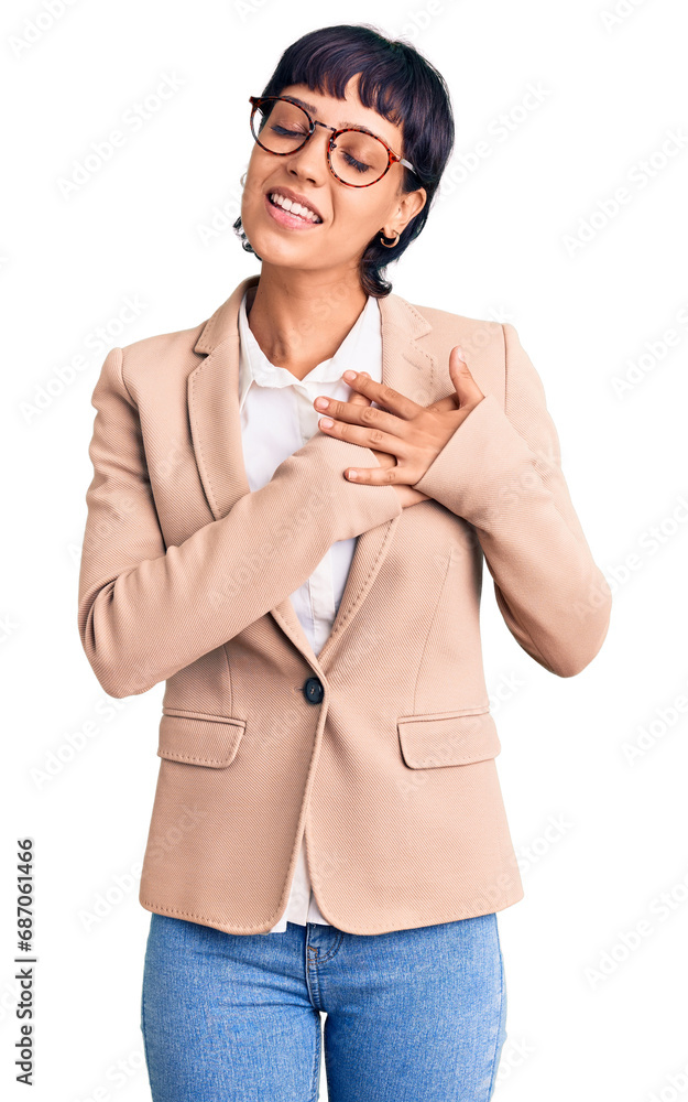 Φωτογραφία Young brunette woman with short hair wearing business jacket and glasses smiling with hands on chest with closed eyes and grateful gesture on face