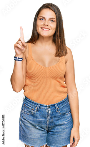 Young caucasian woman wearing casual clothes showing and pointing up with finger number one while smiling confident and happy.