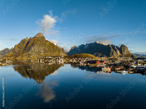 aerial view over reine nordic norwegian village surrounded with moountains with reflections on lofoten islands © Sid Smith