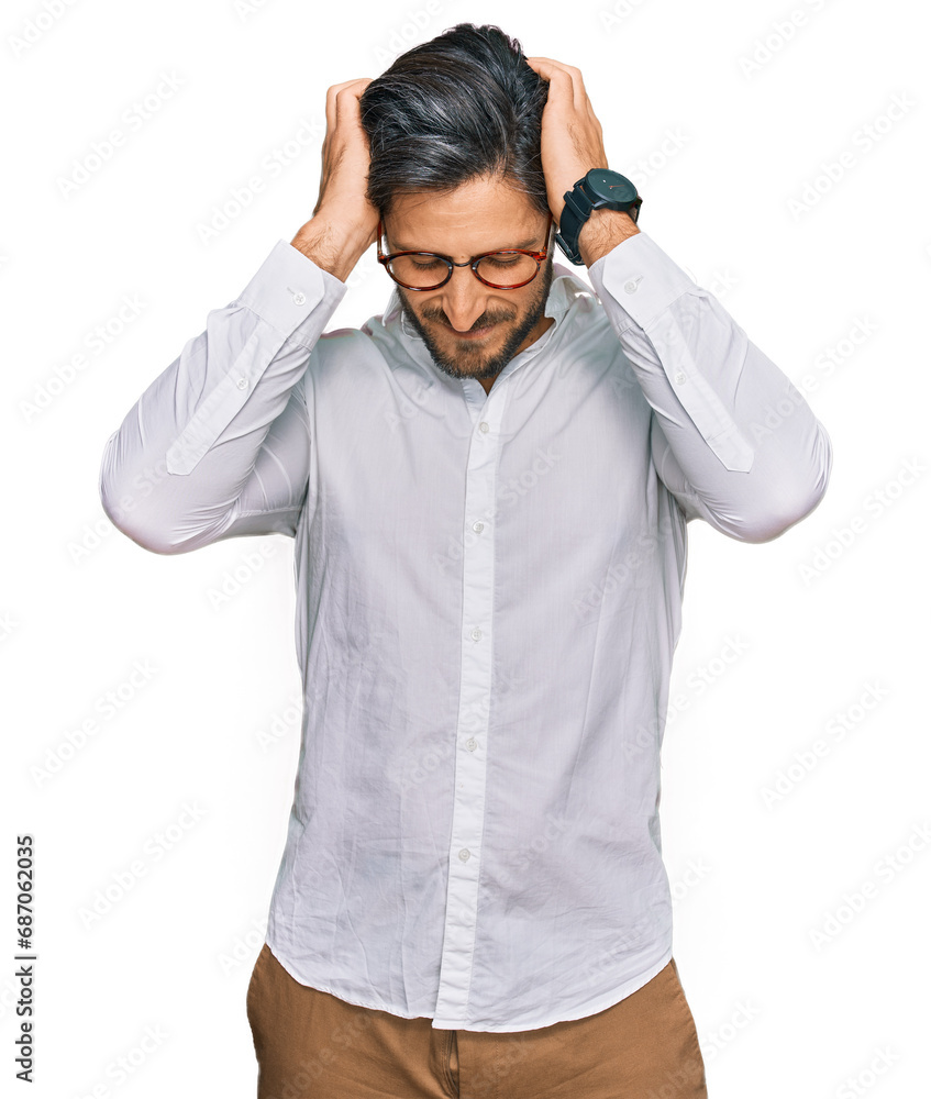 Young hispanic man wearing business shirt and glasses suffering from headache desperate and stressed because pain and migraine. hands on head. Young hispanic man wearing business shirt and glasses suffering from headache desperate and stressed because pain and migraine. hands on head.