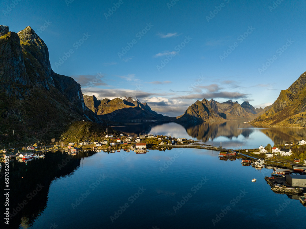 aerial view over reine nordic norwegian village surrounded with moountains with reflections on lofoten islands